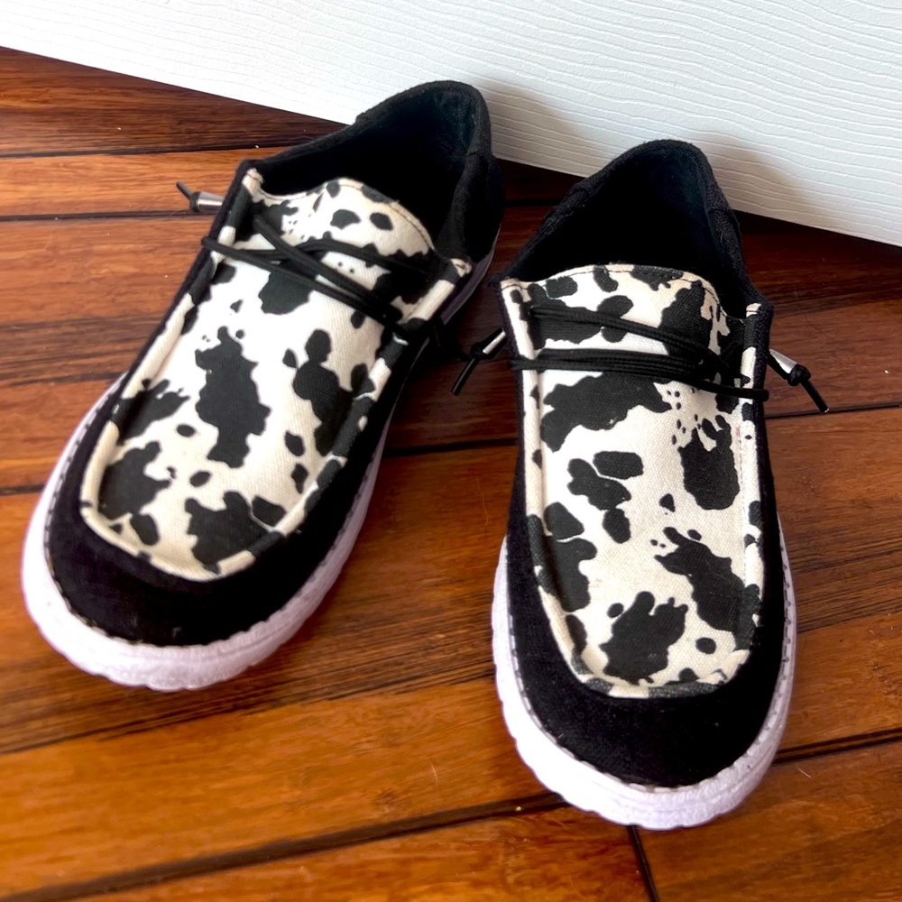 Cow print hey dude style shoes.